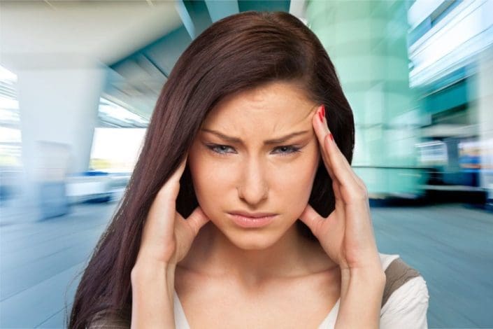 Woman with headache in front of blurry surroundings