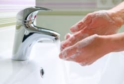 Person washing their hands in a sink