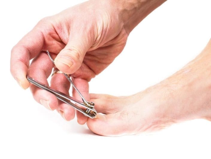 closeup of person cutting toenails