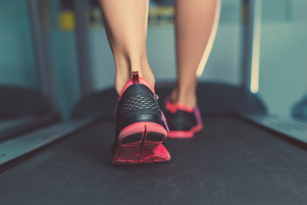A close-up of feet walking on a treadmill