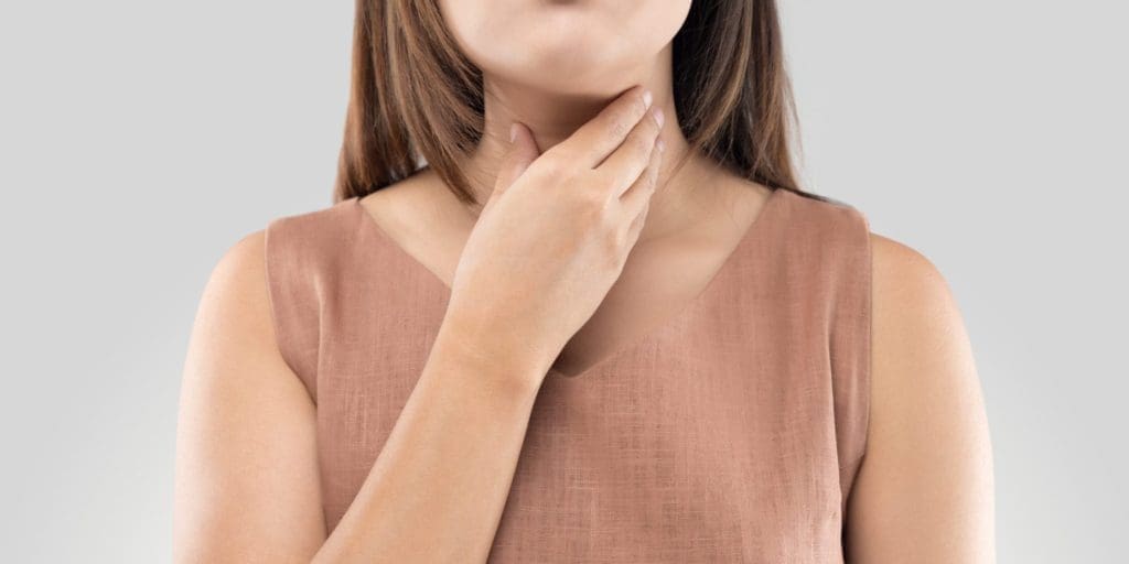 Woman touching her throat because it is sore