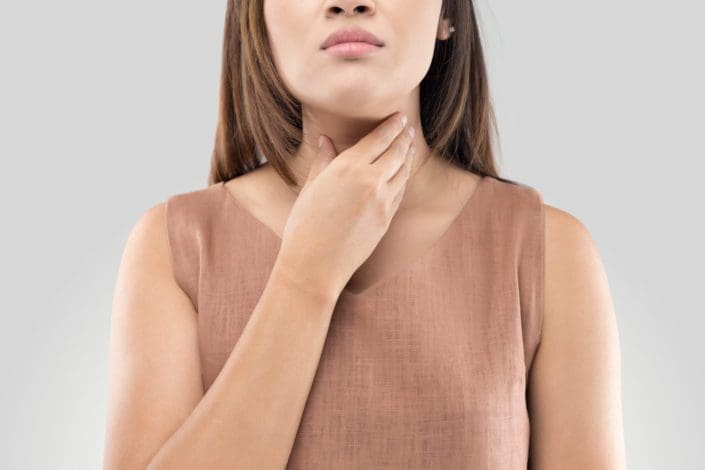 Woman touching her throat because it is sore