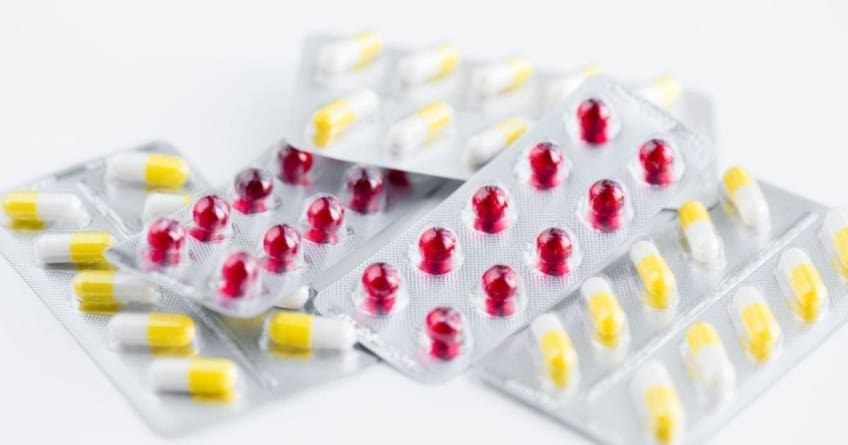 Red and yellow pills in foil packaging.