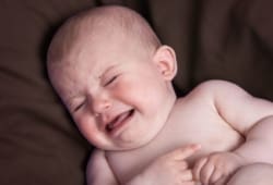 A baby cries in distress. Intussusception is a serious problem with the intestine that prevents the passage of food through the intestine. It is a medical emergency.