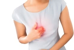 A woman pressing on her chest due to heartburn pain