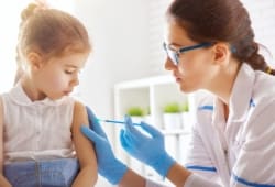 doctor gives achickenpox vaccination to a young girl