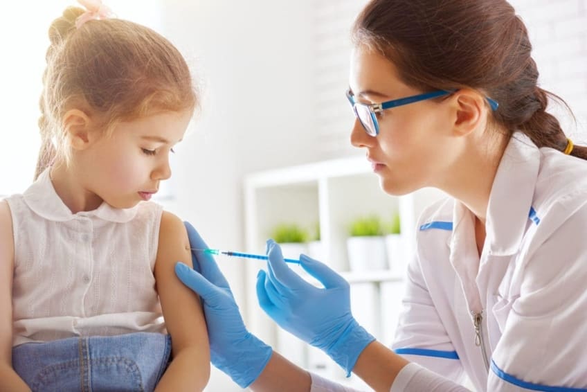 doctor gives a chickenpox vaccination to a young girl