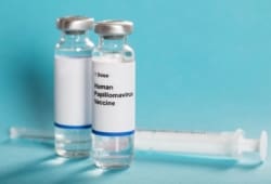 Bottle of HPV vaccine sitting next to syringe