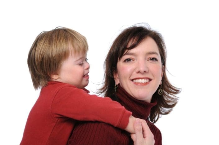 Woman holding son with Down syndrome on her back