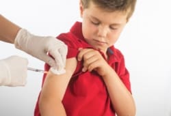 doctor or nurse giving child a shot in the arm