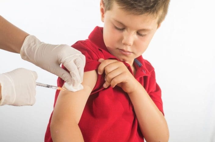 doctor or nurse giving child a shot in the arm