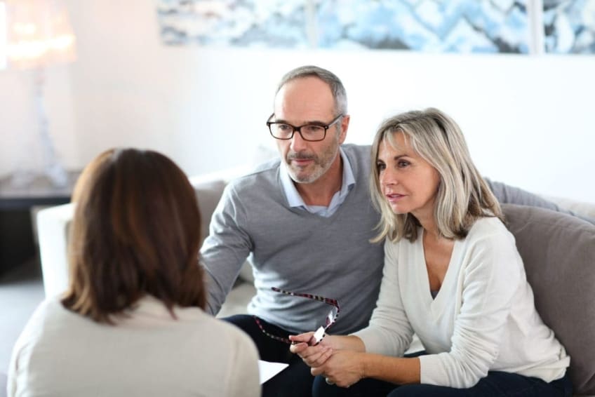 middle-aged couple go over paperwork with a lawyer