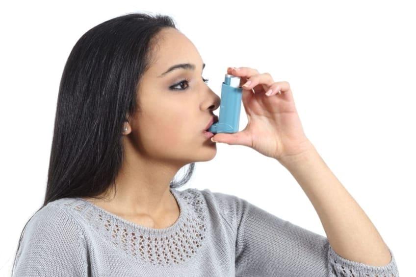 A woman breathing from an inhaler