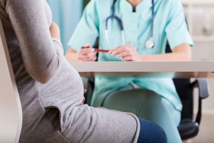 pregnant woman talks with doctor during a medical visit