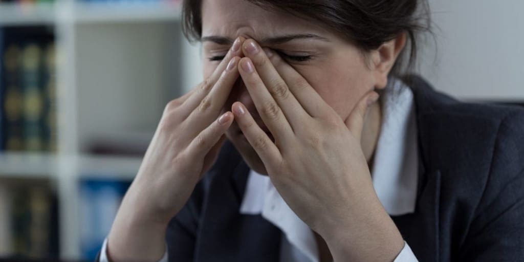 Woman in business clothes holding sinuses in pain