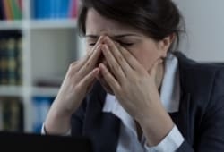 Woman in business clothes holding sinuses in pain