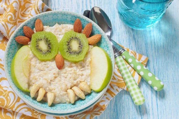 kids breakfast of oatmeal layered with fruit and nuts so it looks like an owl