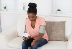 Young Woman Checking Blood Pressure At Home