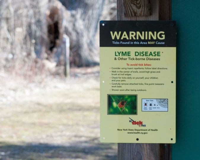 Tick warning sign posted in a nature park