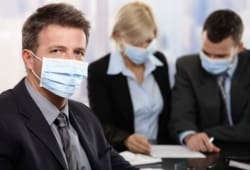 colleagues wear protective facemasks during a meeting at work
