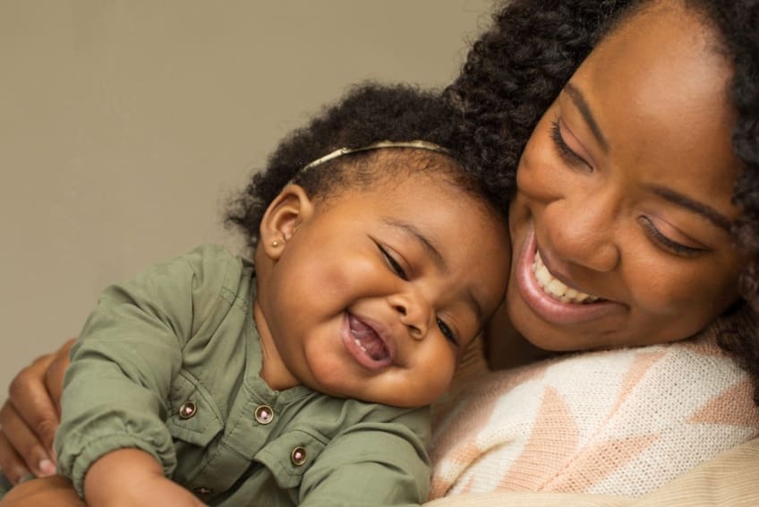 close-up of mother hugging her baby daughter