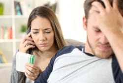 Wife calling doctor on phone to help her ill husband