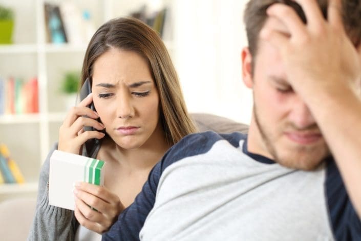 Wife calling doctor on phone to help her ill husband