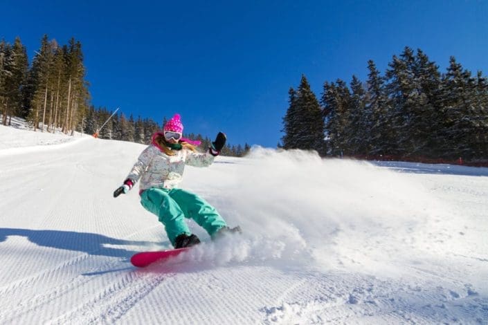A woman snowboarding on a sunny day
