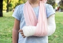 Child with broken arm and cast in sling