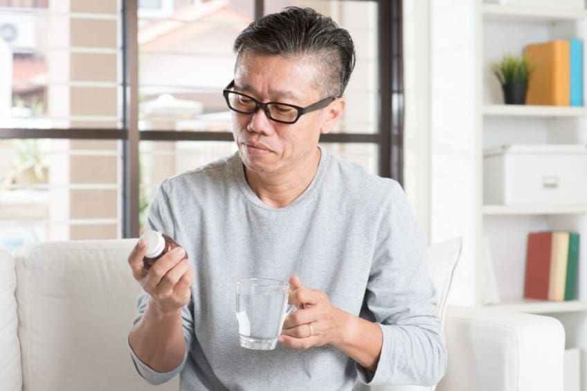 Middle-aged man reads a medicine bottle label. Methotrexate is a strong medicine that is used to treat some types of cancer, rheumatoid arthritis, psoriasis, and several other conditions.