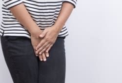 Woman with hands crossed over her pelvis as if she is in pain or needs to use the restroom. Interstitial cystitis is chronic inflammation of the bladder. This inflammation can scar the bladder or make it stiff.