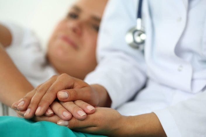 A doctor holds a cancer patient’s hand. Cancer is a collection of many diseases that all involve the growth of abnormal cells. Some common forms are skin, breast and prostate cancer.