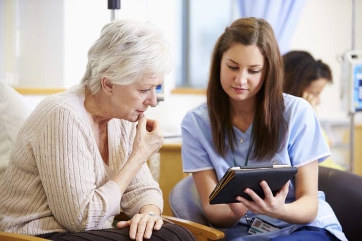 Senior woman consults with nurse before chemotherapy