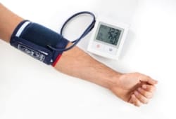 man wearing blood pressure monitor on arm