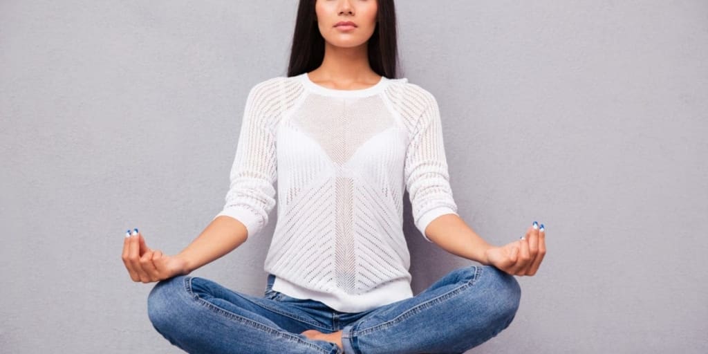 Woman sitting cross-legged on floor, meditating