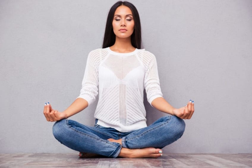 Woman sitting cross-legged on floor, meditating