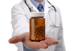 A doctor holding out a bottle of pills