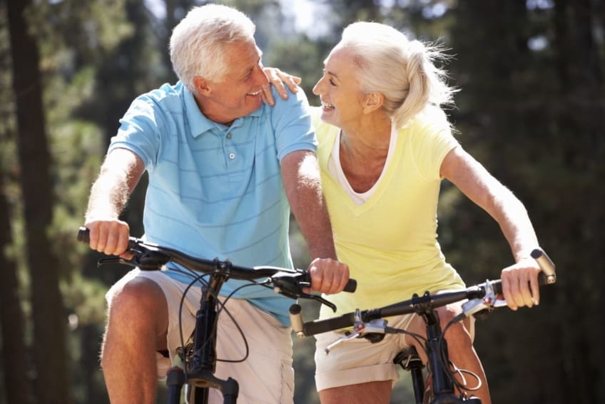 A older couple biking together outdoors