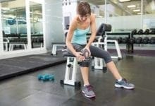 Fit woman wearing a knee brace in a gym