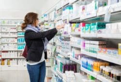 A women looks for supplies in the aisle of a pharmacy