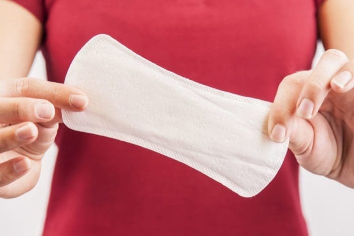 Woman holding clean menstrual pad