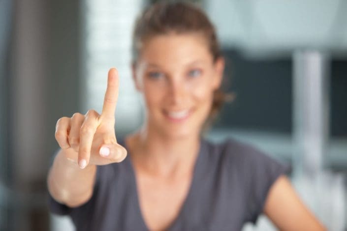 A woman holding up her pointer finger