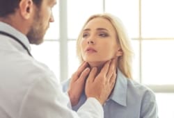 doctor examining female patient for hypothyroidism while working in his office