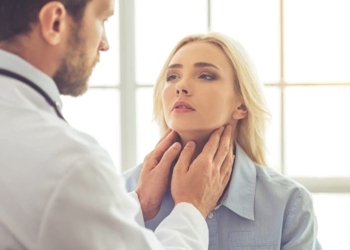 doctor examining female patient for hypothyroidism while working in his office