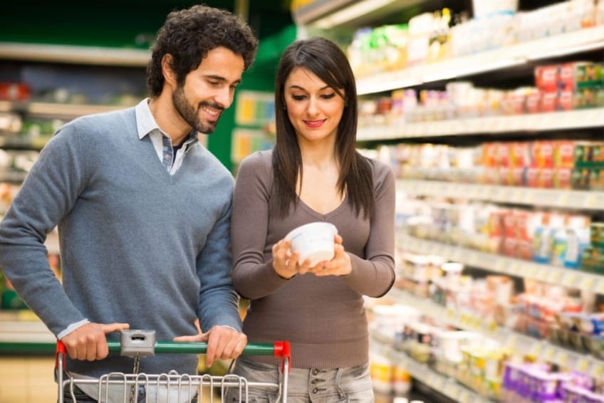 Young couple reading a nutrition label in the supermarket