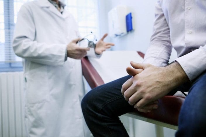 A man sits on an exam table in a doctor’s office. Testicular torsion is an emergency that happens when a man’s testicles rotate and the spermatic cord becomes twisted. It can occur at any age.
