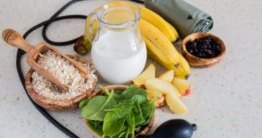 Healthy food and drink choices often included in the dash diet plan, sitting on a table surrounded by blood pressure monitor