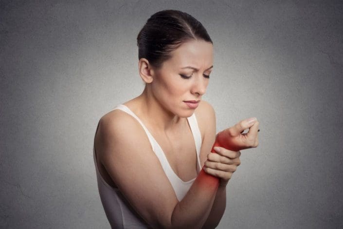 Woman holds her wrist in pain