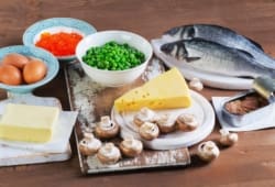Fish, eggs, dairy products and vegetables sitting on table. Vitamin D is a nutrient that helps your body build strong bones and teeth. You can get it from foods, sunlight, and dietary supplements.