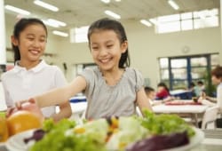 Students reaching for healthy food in school cafeteria
